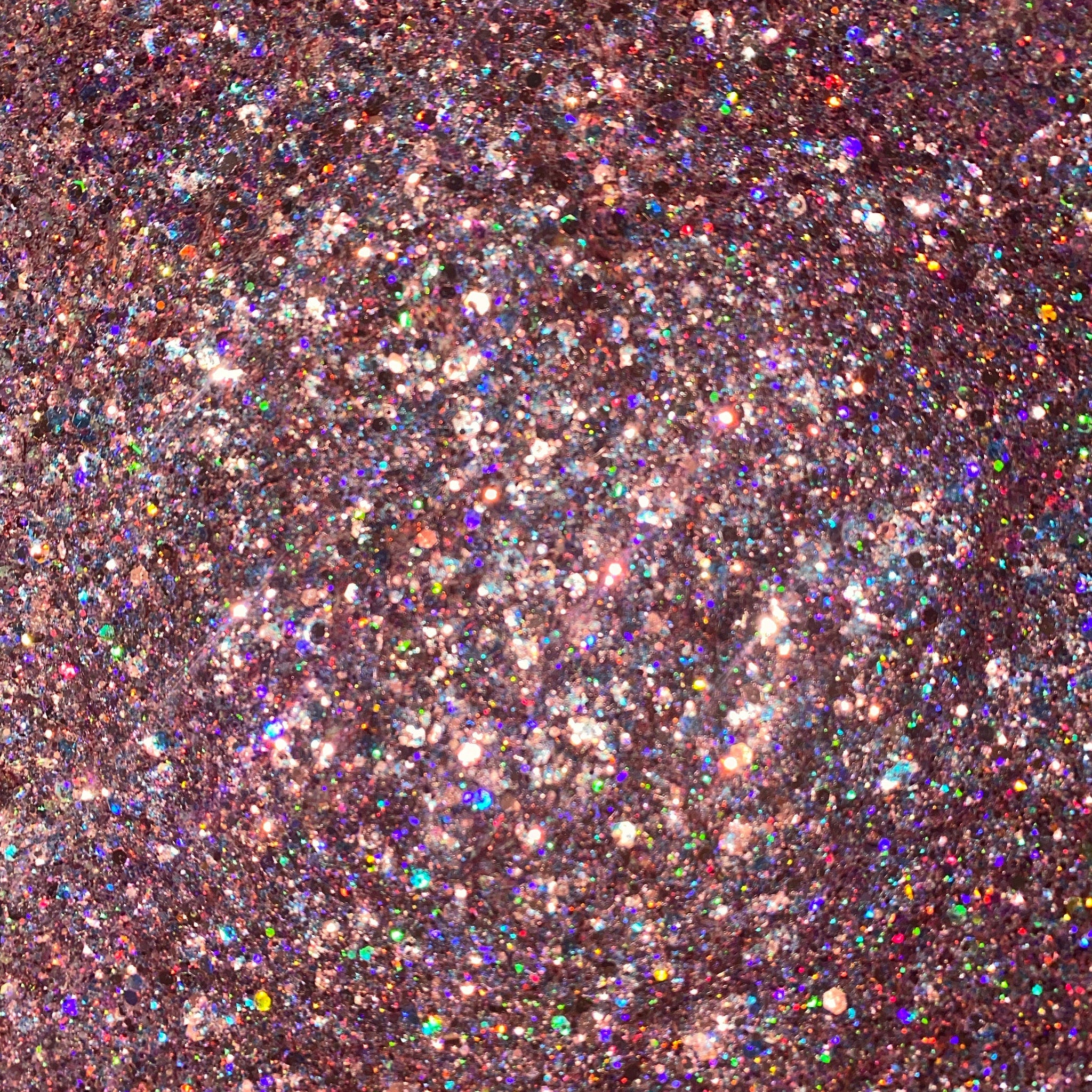 Close-up of rosé pink glitter eyeshadow with shimmering particles and smooth pressed powder texture