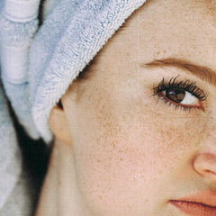 Freckled skin with blue towel, close-up of eye and face, light skin tone and soft texture