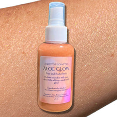 Translucent pink spray bottle of aloe glow shimmer mist with gold nozzle and minimalist label