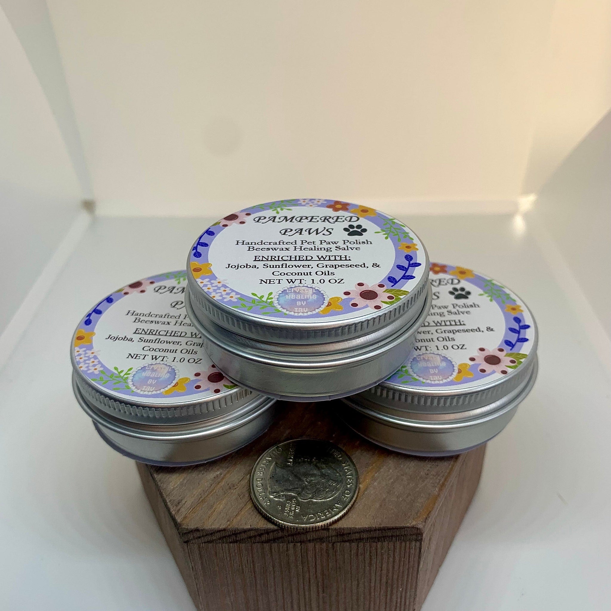 Paw polish tins with floral labels, silver metal, and "Pampered Paws" text displayed