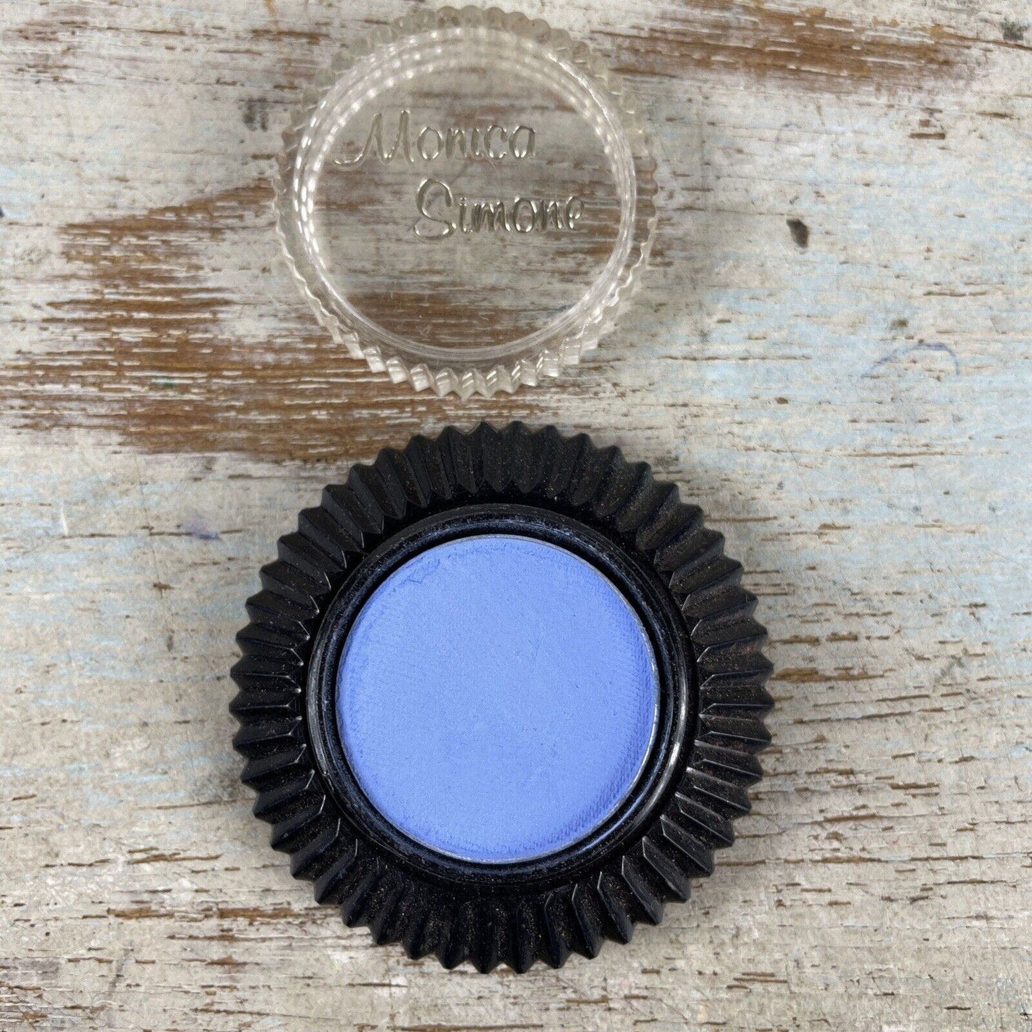Side view of Vintage Monica Simone eyeshadow compact showing retro floral pattern and gold-trimmed edges