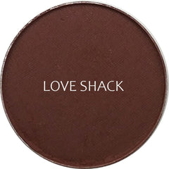 Side view of matte Love Shack eyeshadow pan showing rich taupe pigment and smooth pressed powder texture