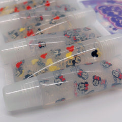 Lip gloss tubes with Mickey Mouse pattern, clear liquid, and white caps.