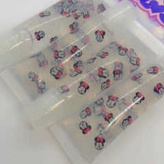 Lip gloss tubes with clear liquid, Minnie Mouse pattern, and white caps