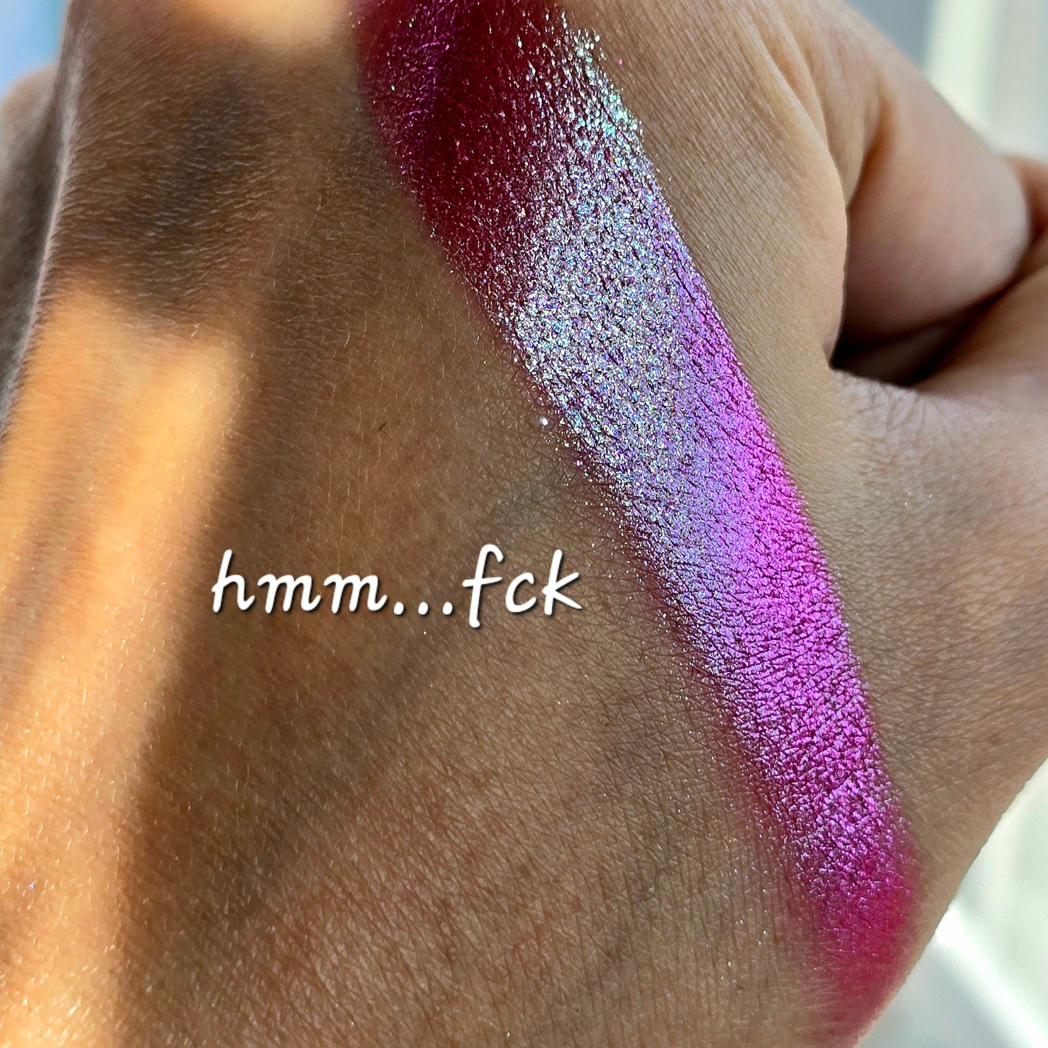 Extreme close-up of shimmery multichrome eyeshadow shifting between emerald green and sapphire blue hues