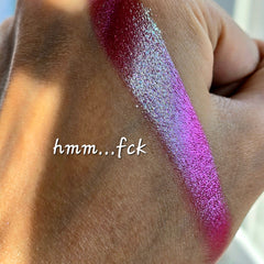 Extreme close-up of shimmery multichrome eyeshadow shifting between emerald green and sapphire blue hues