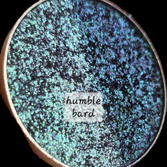 Extreme close-up of shimmery multichrome eye shadow shifting between vibrant hues with sparkling flecks