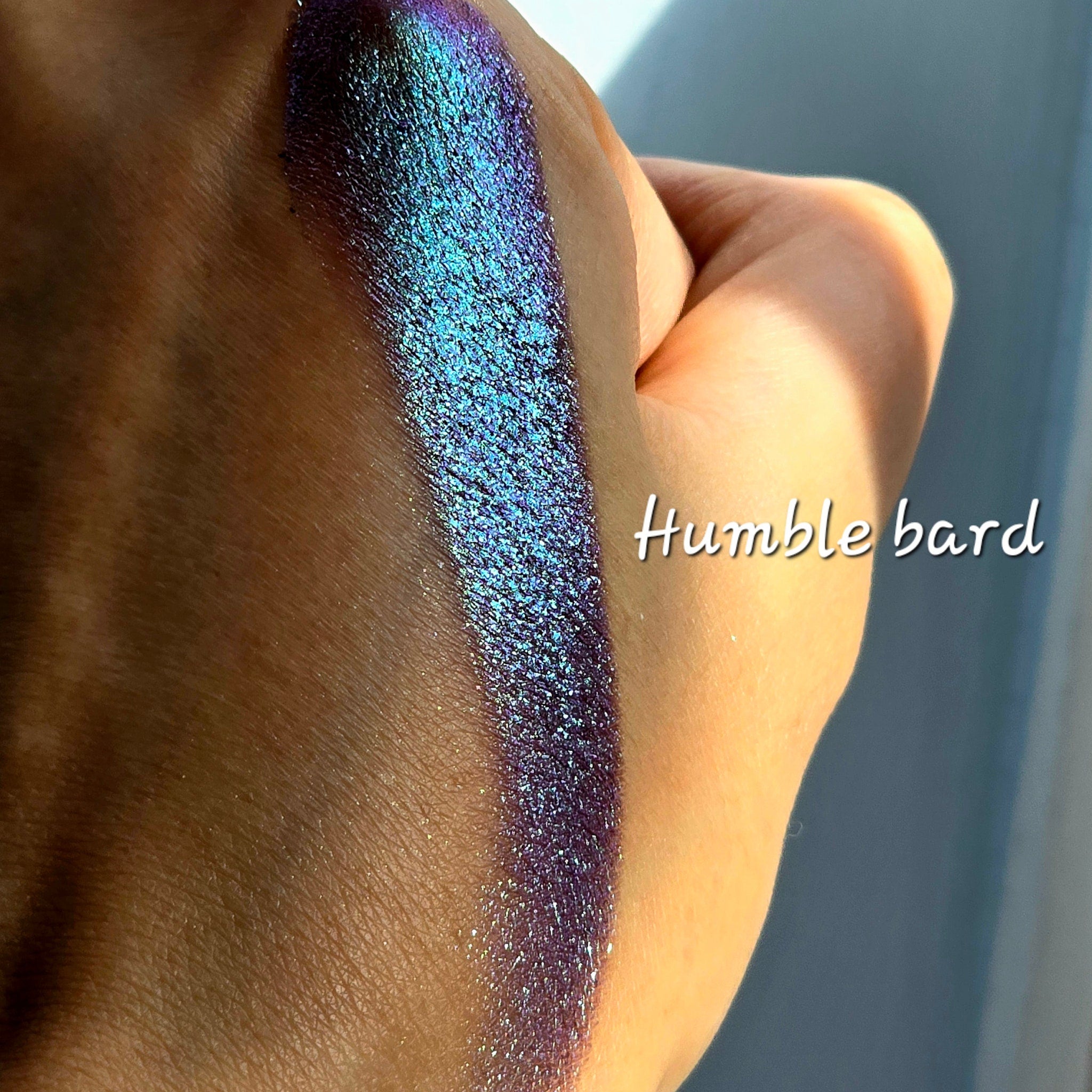 Side view of Humble Bard multichrome eye shadow pot showcasing intense shimmery color shift from bronze to green