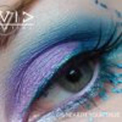 Eyeshadow with blue, purple, and silver shimmer, applied to eye for makeup look, with "VI" logo visible