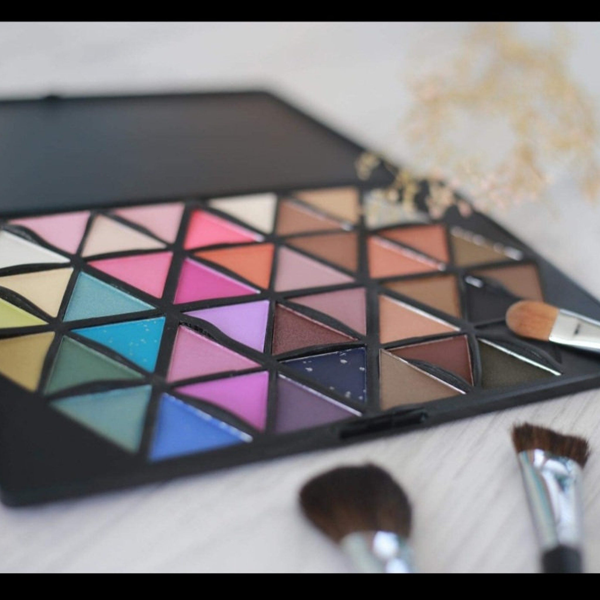 Close-up of Vivid Cosmetics eyeshadow palette showcasing a vibrant teal shade with shimmer finish