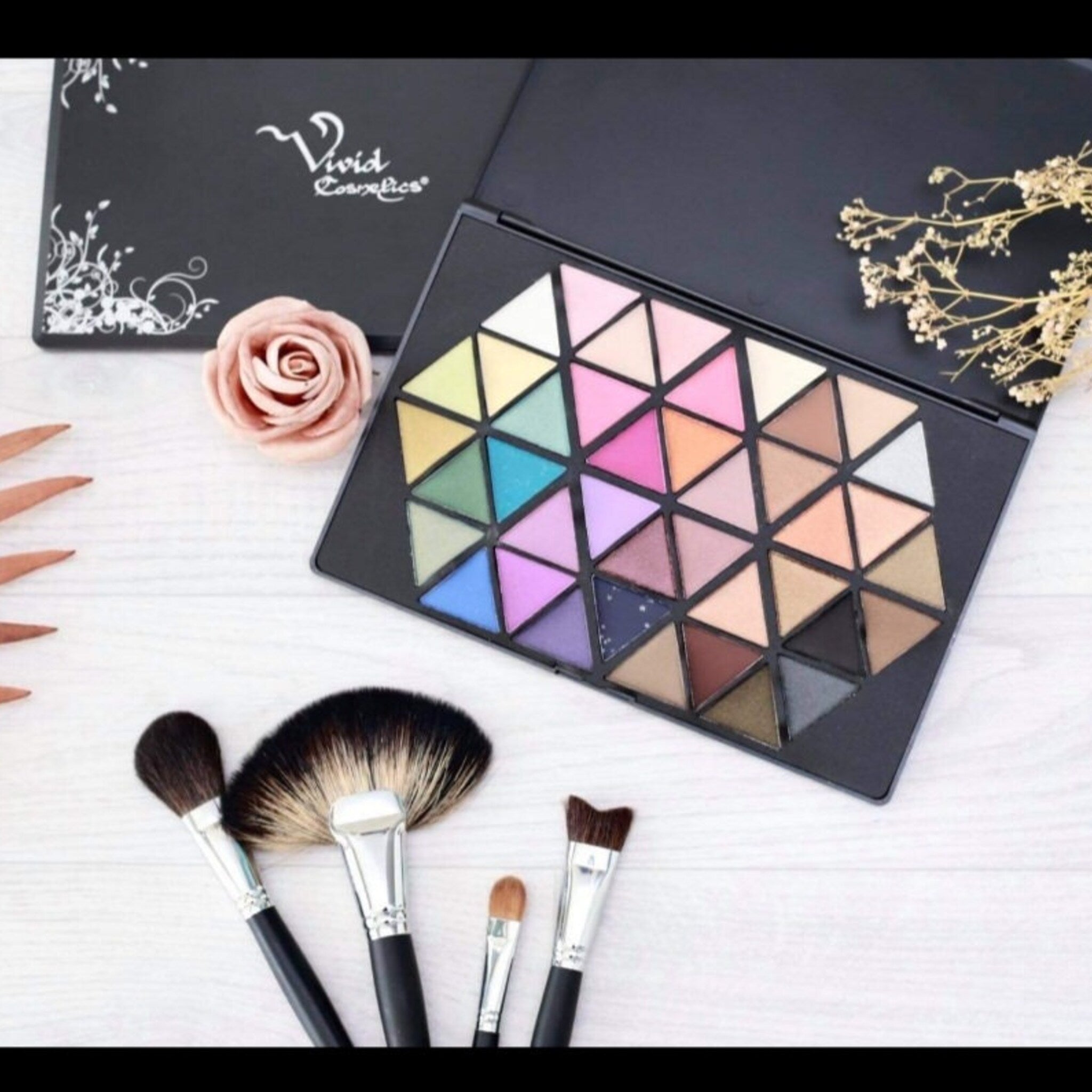Side view of Vivid Cosmetics eyeshadow palette showing gradient of matte and shimmer shades in warm tones
