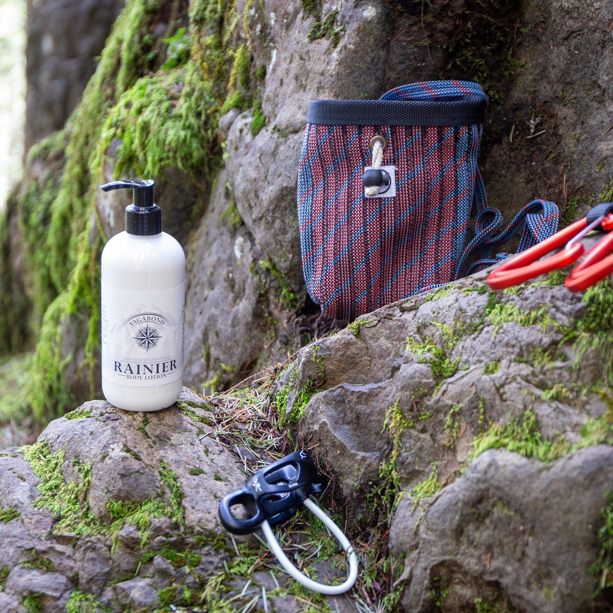 Body lotion bottle with white bottle, black pump, and Rainier label on a rock