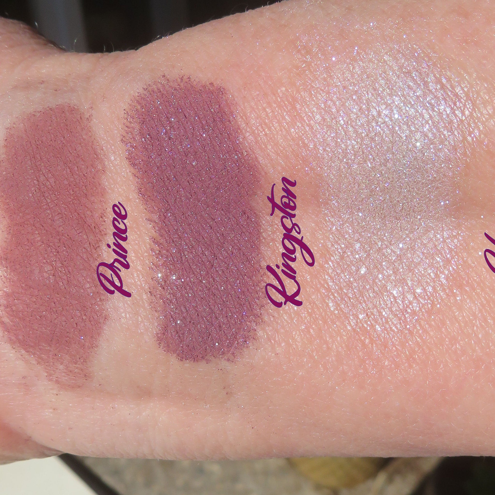 Three loose mineral eyeshadows in dark mauve matte and purple shimmer shades with vegan labeling