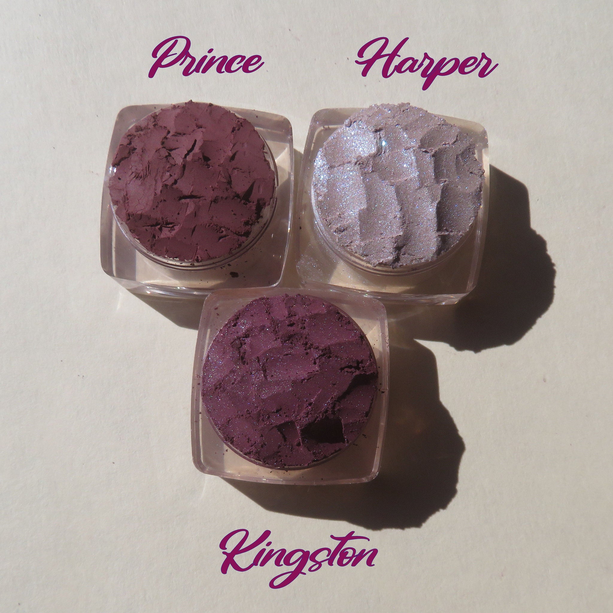 Side view of three purple shimmer loose pigment jars showing mineral texture and mauve matte shade variation