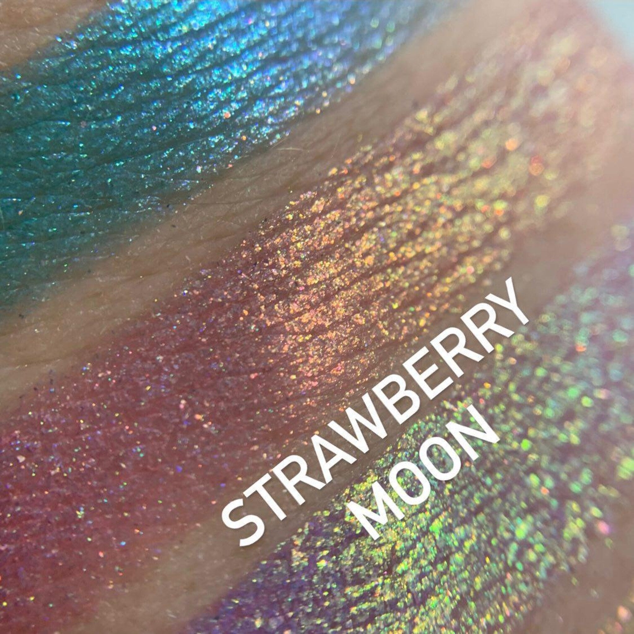 Side view of Chrome Shifting Strawberry Moon eyeshadow palette showing iridescent pink and gold shift in compact case