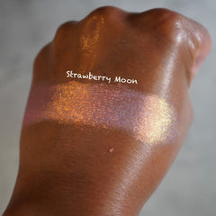 Close-up of shimmery pink and gold shifting eyeshadow with reflective chrome finish in compact palette
