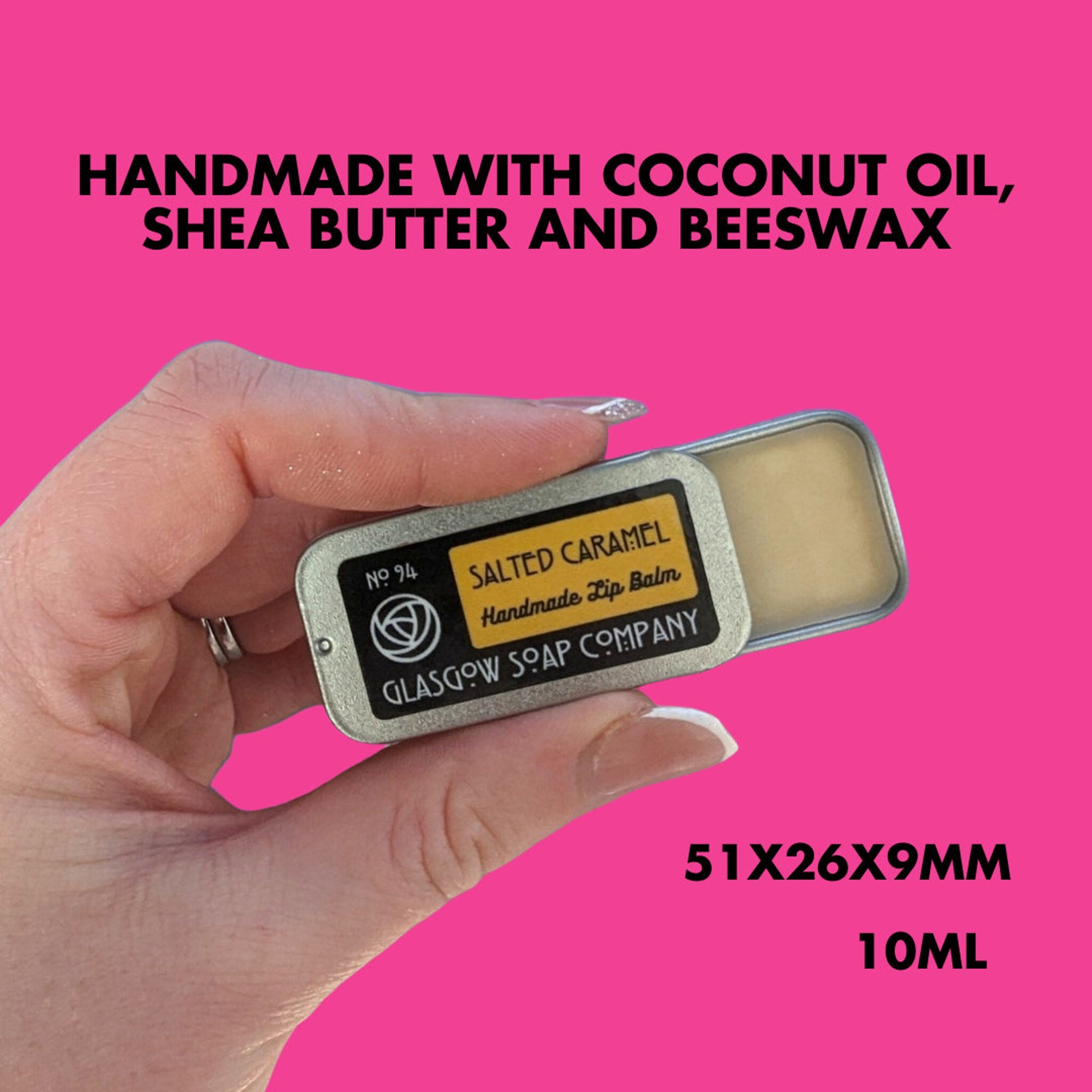 Lip balm tin with silver metal, yellow label, and Glasgow Soap Company text, held in hand