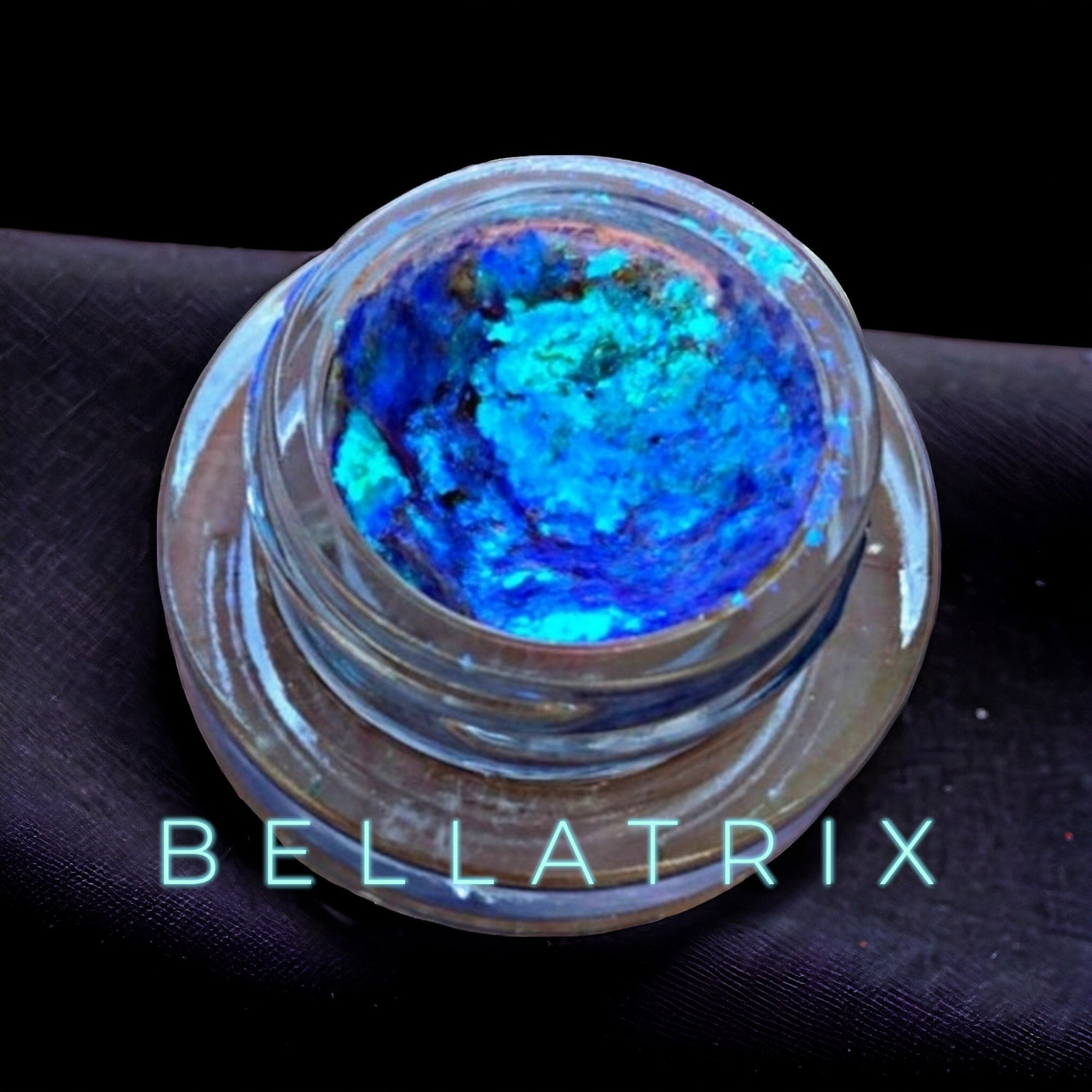 Hand applying creamy chrome eyeshadow with fingertip, showcasing smooth metallic finish on eyelid.