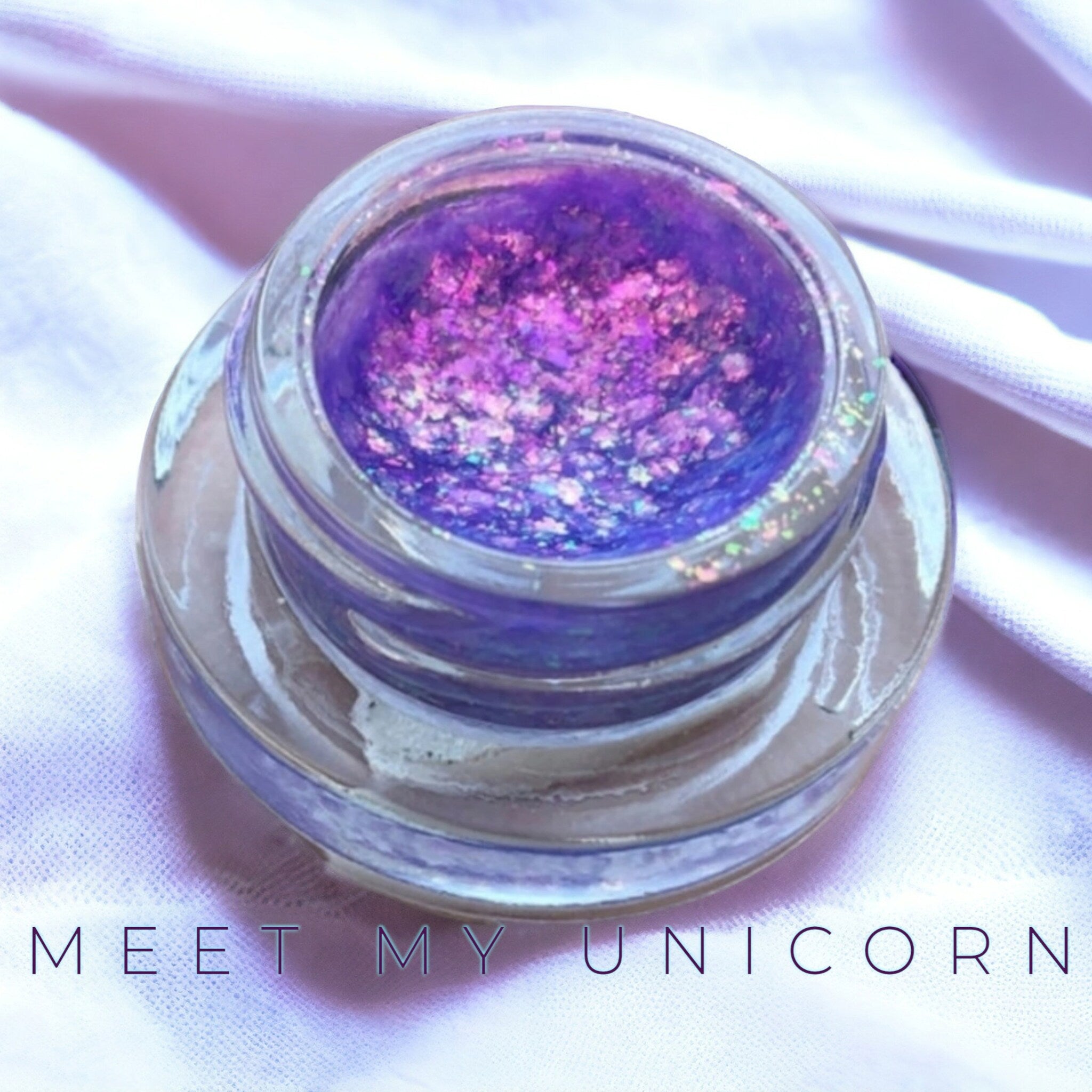 Side view of creamy chrome eyeshadow pots showcasing reflective metallic finish and compact round packaging