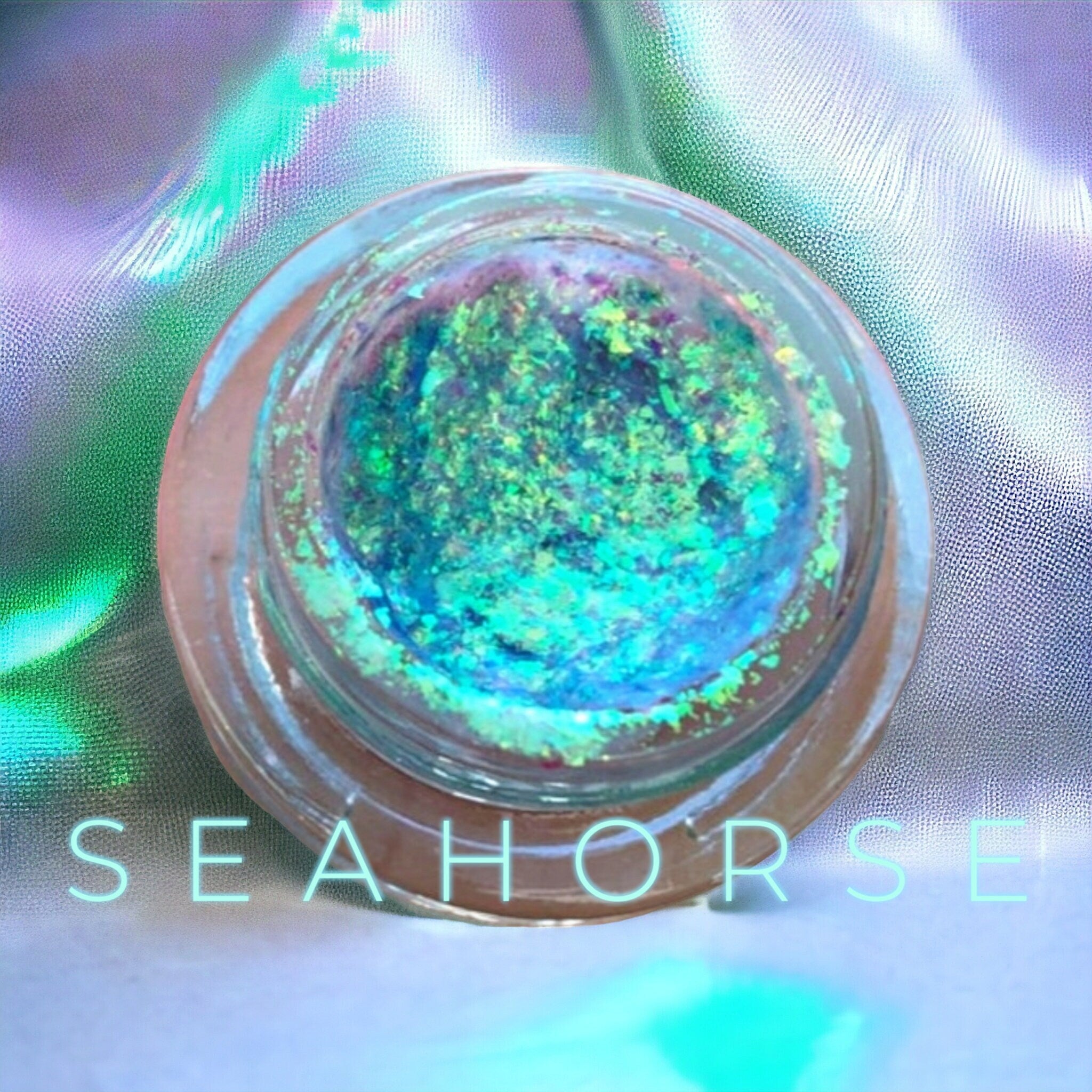 Close-up of creamy chrome eyeshadow pots with reflective metallic finishes in assorted shades.