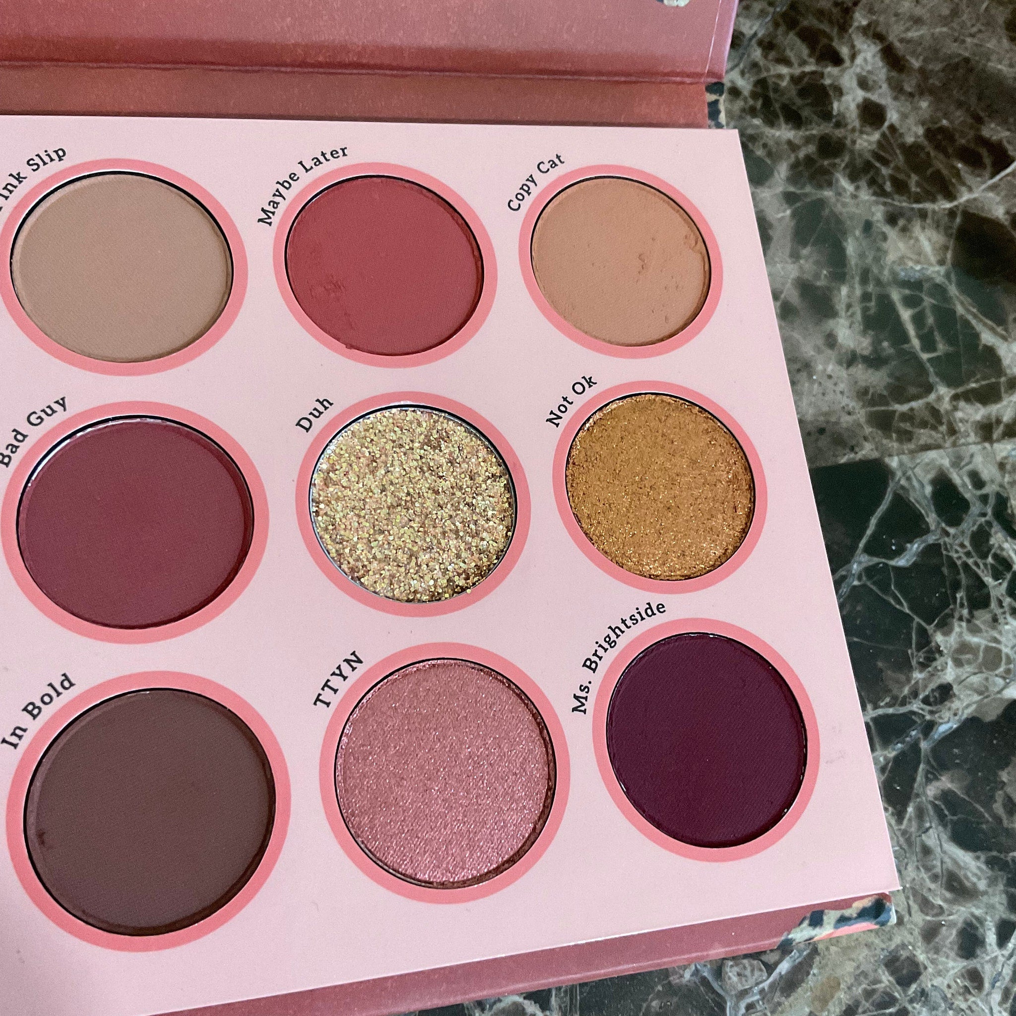 Side view of Colourpop Whatever Palette showing sleek black compact with gold lettering and shadow pans