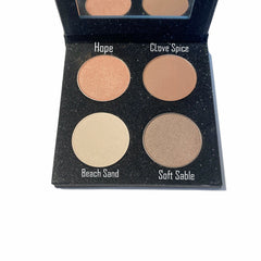 Close-up of four refillable matte eye shadows in warm nude tones inside a sleek paperboard palette