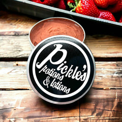 Pickle's brand tin with black and white label, silver rim, and brown contents, on wood surface