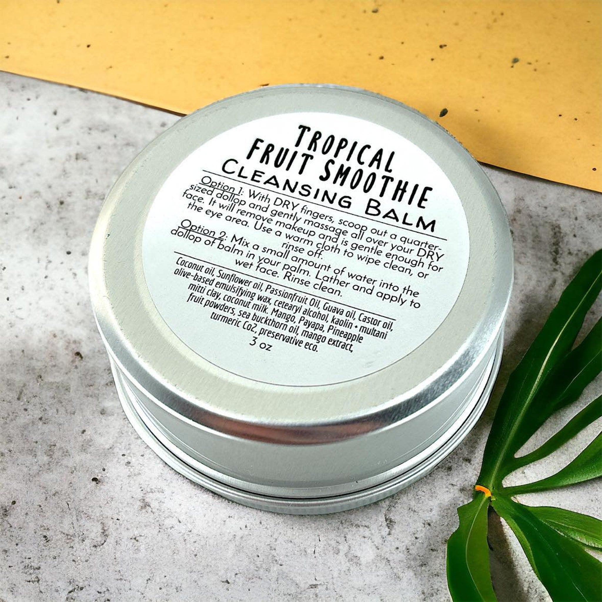 Cleansing balm in silver metal tin with white label, Tropical Fruit Smoothie text visible