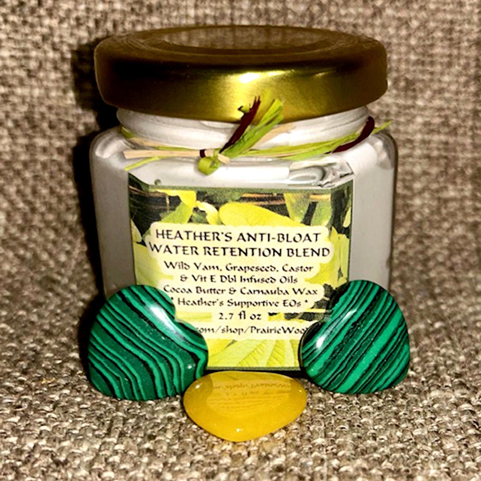 Skin care cream jar with gold lid, green and black heart-shaped stones, Heather's brand label visible
