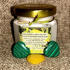 Skin care cream jar with gold lid, green and black heart-shaped stones, Heather's brand label visible