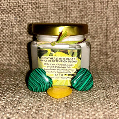 Anti-bloat blend jar with gold lid, green and black stone accents, and Heather's label visible