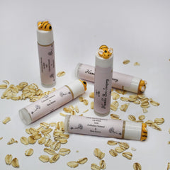 Lip balm tubes with yellow bee toppers, pink labels, and white tubes, The Humble Bee Soapery brand