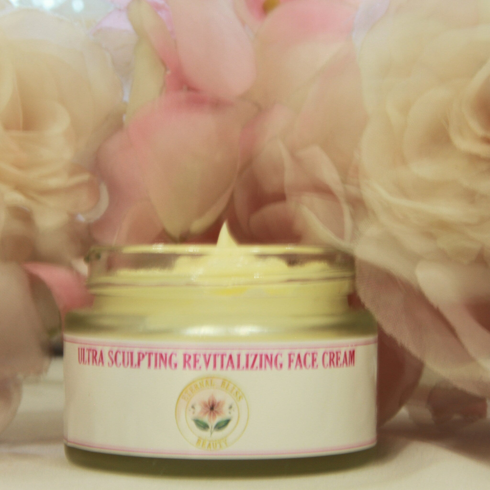 Hand applying pearl-sized dollop of Revitalizing Ultra Sculpt Face Cream onto cheekbone