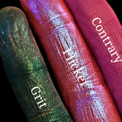 Side view of Divergence palette showing stacked eyeshadow pans with vibrant matte and shimmer shades in sleek black packaging