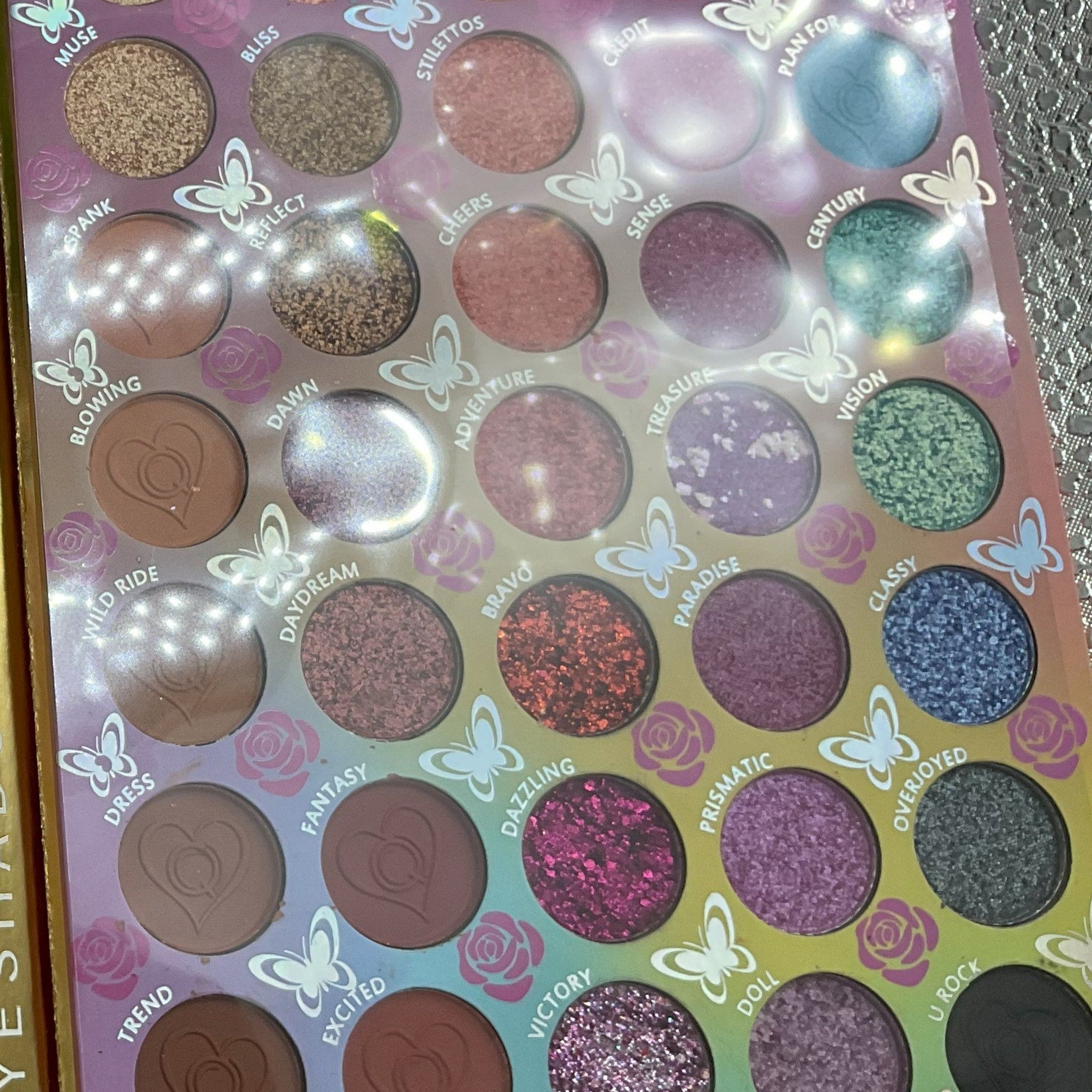 Eyeshadow palette with multiple colors, glitter, and matte finishes for eye makeup application