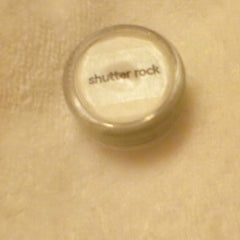 Close-up of pressed powder eye shadow showing smooth texture and rich pigment in compact palette