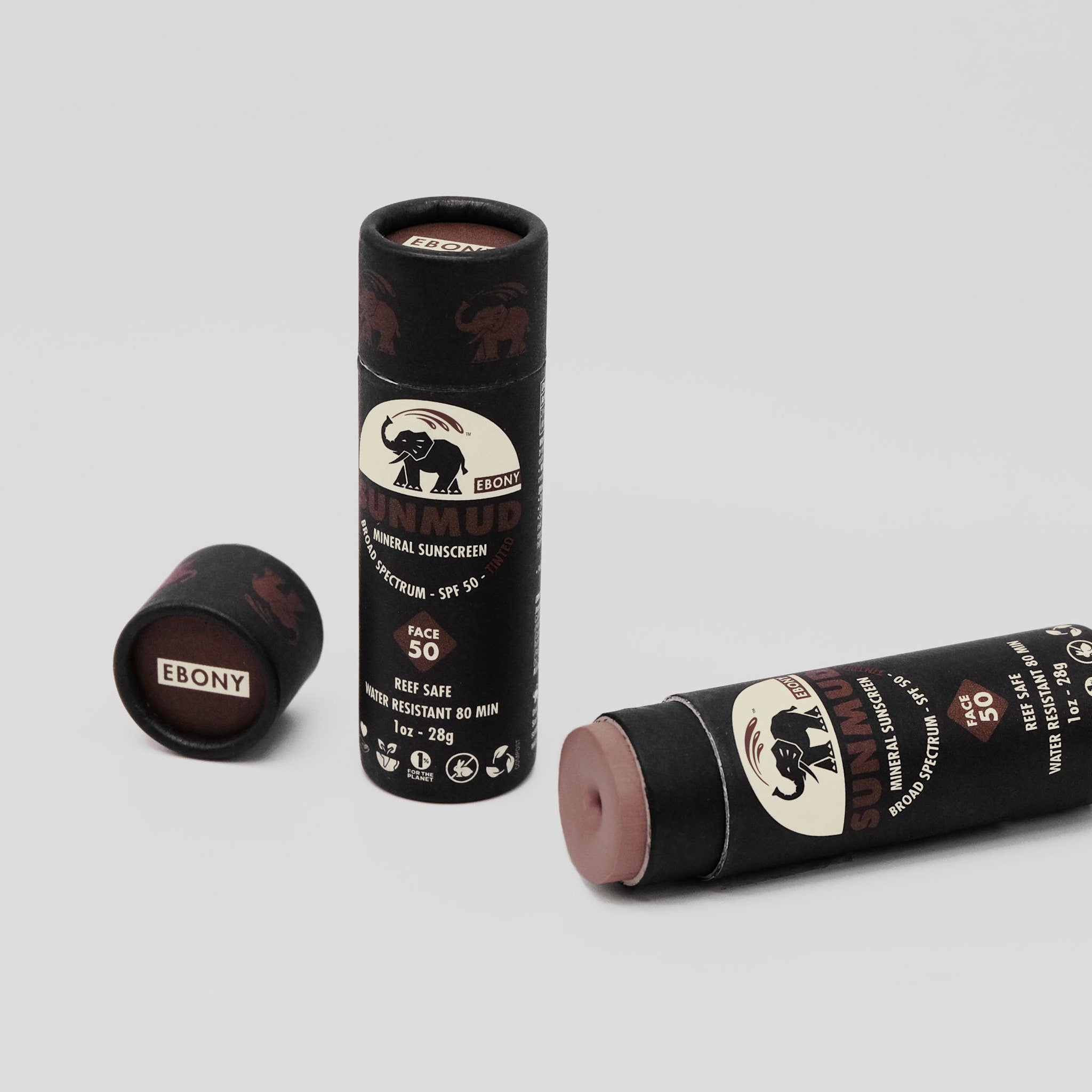 Sunscreen stick with black paper tube, brown tinted balm, and "EBONY" text visible