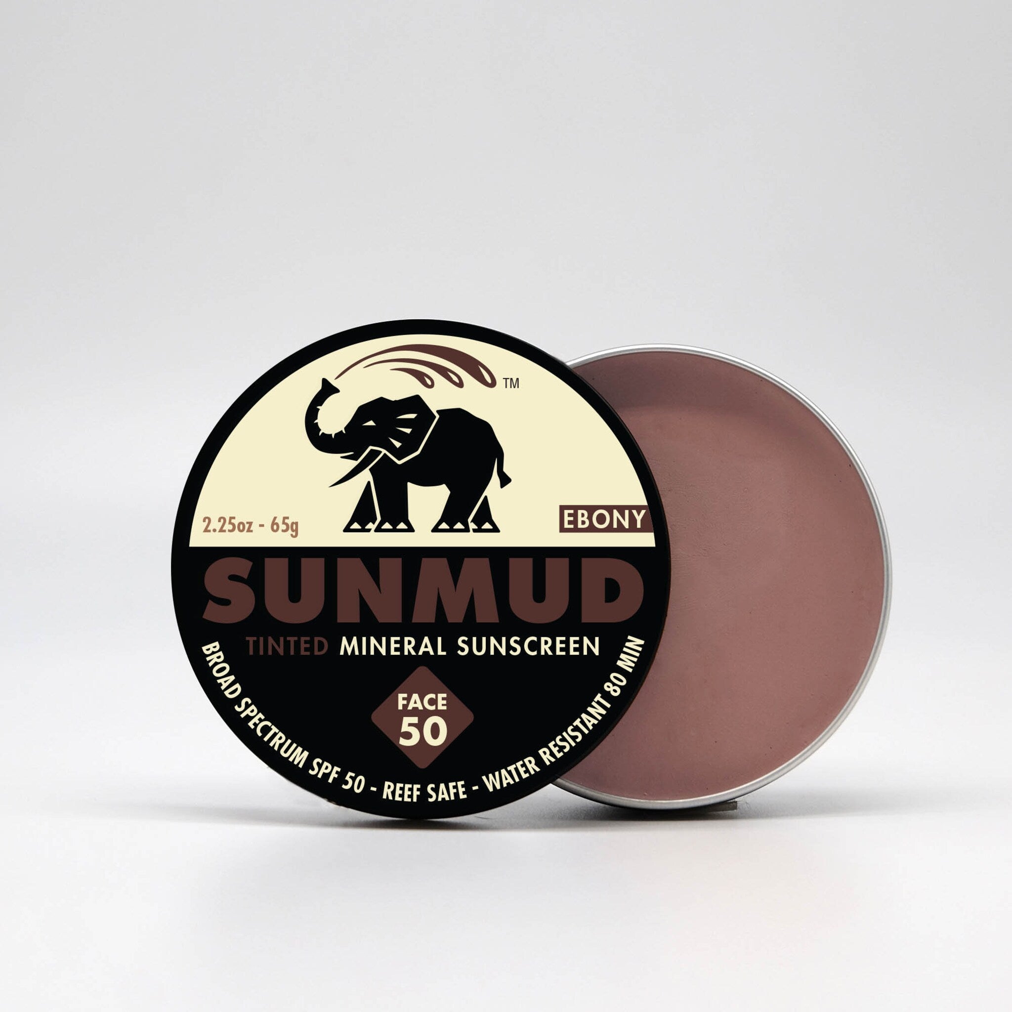 Tinted mineral sunscreen in a round metal tin, with black and cream label, and brown product inside