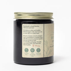 Jar with gold lid, black glass, and tan label with text and illustrations.