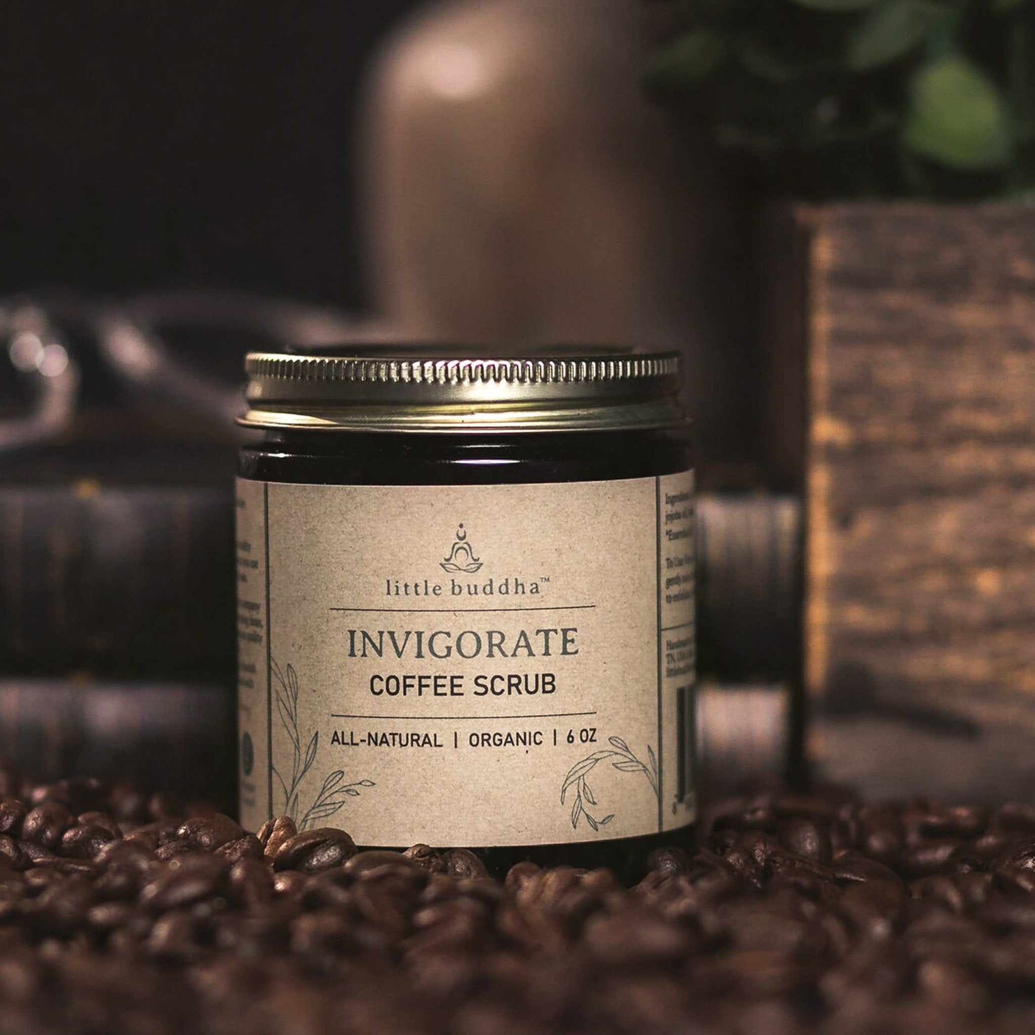 Coffee scrub jar with brown label, metal lid, and "little buddha" branding on display