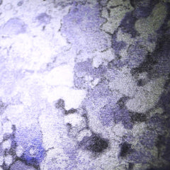 Close-up of shimmering purple and silver marbleized eyeshadow pans in sleek black palette