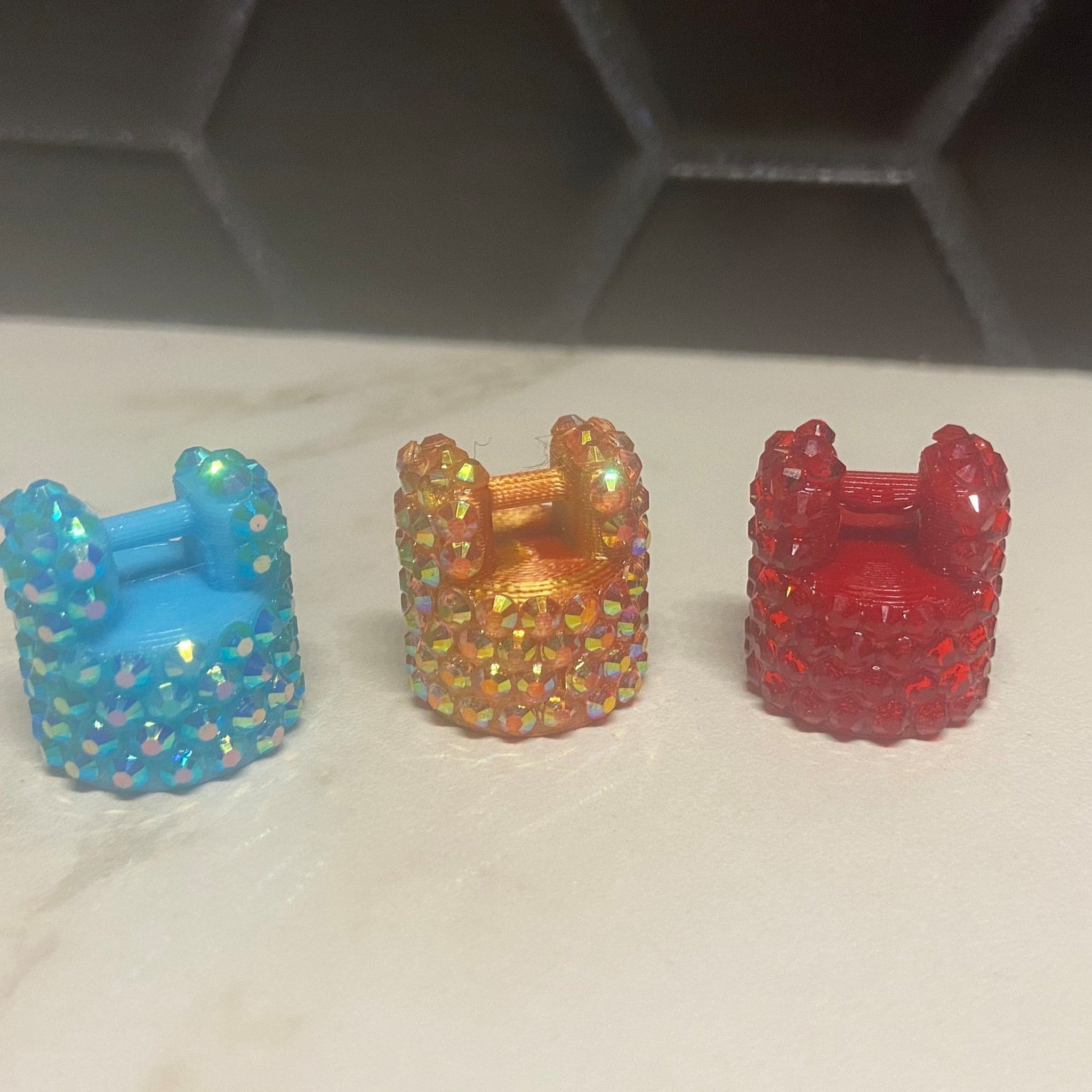 Miniature chair toys in blue, orange, and red with crystal-like embellishments