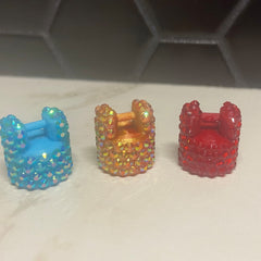 Miniature chair toys in blue, orange, and red with crystal-like embellishments