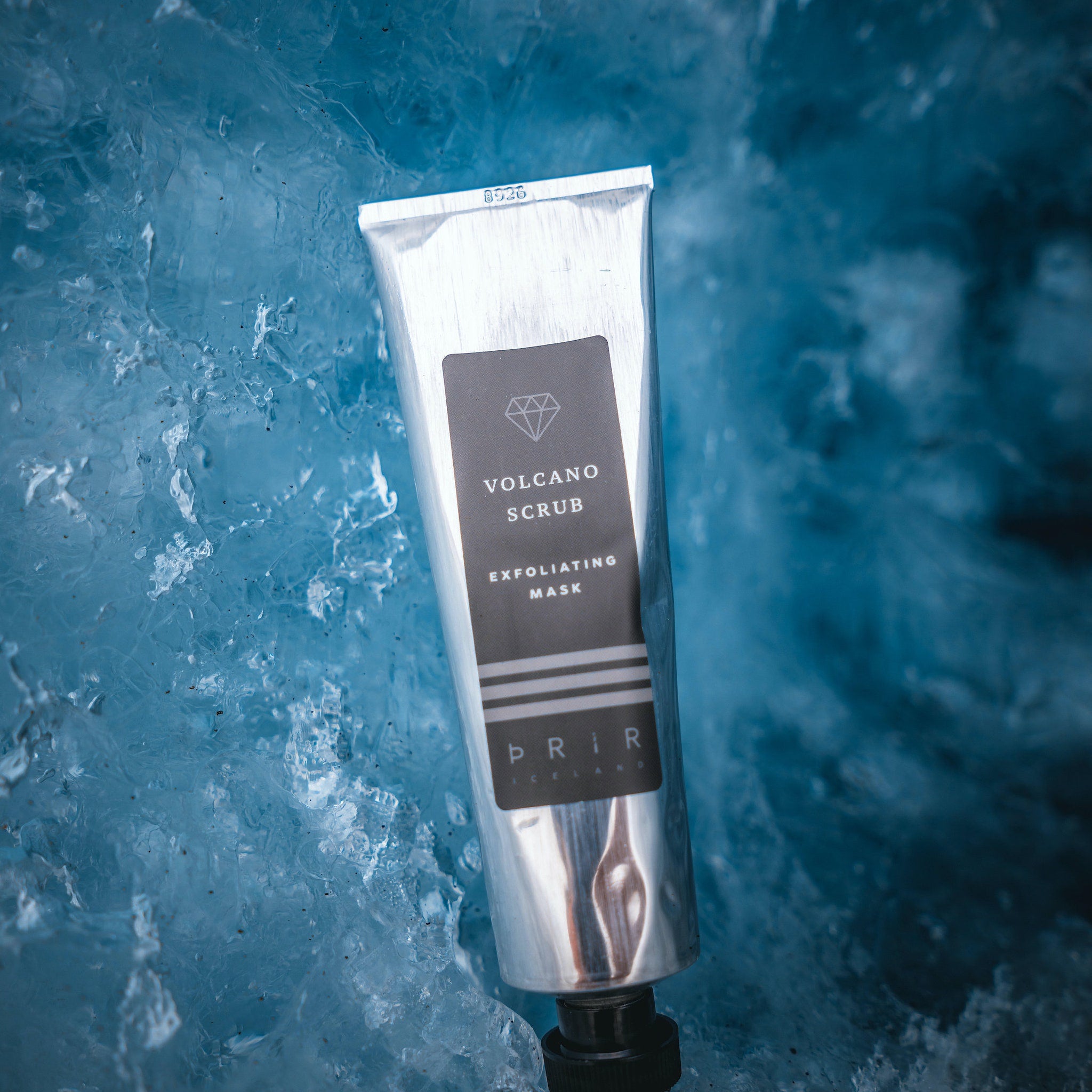 Volcano scrub tube, silver metallic, black label, PRIR Iceland brand, on blue ice background