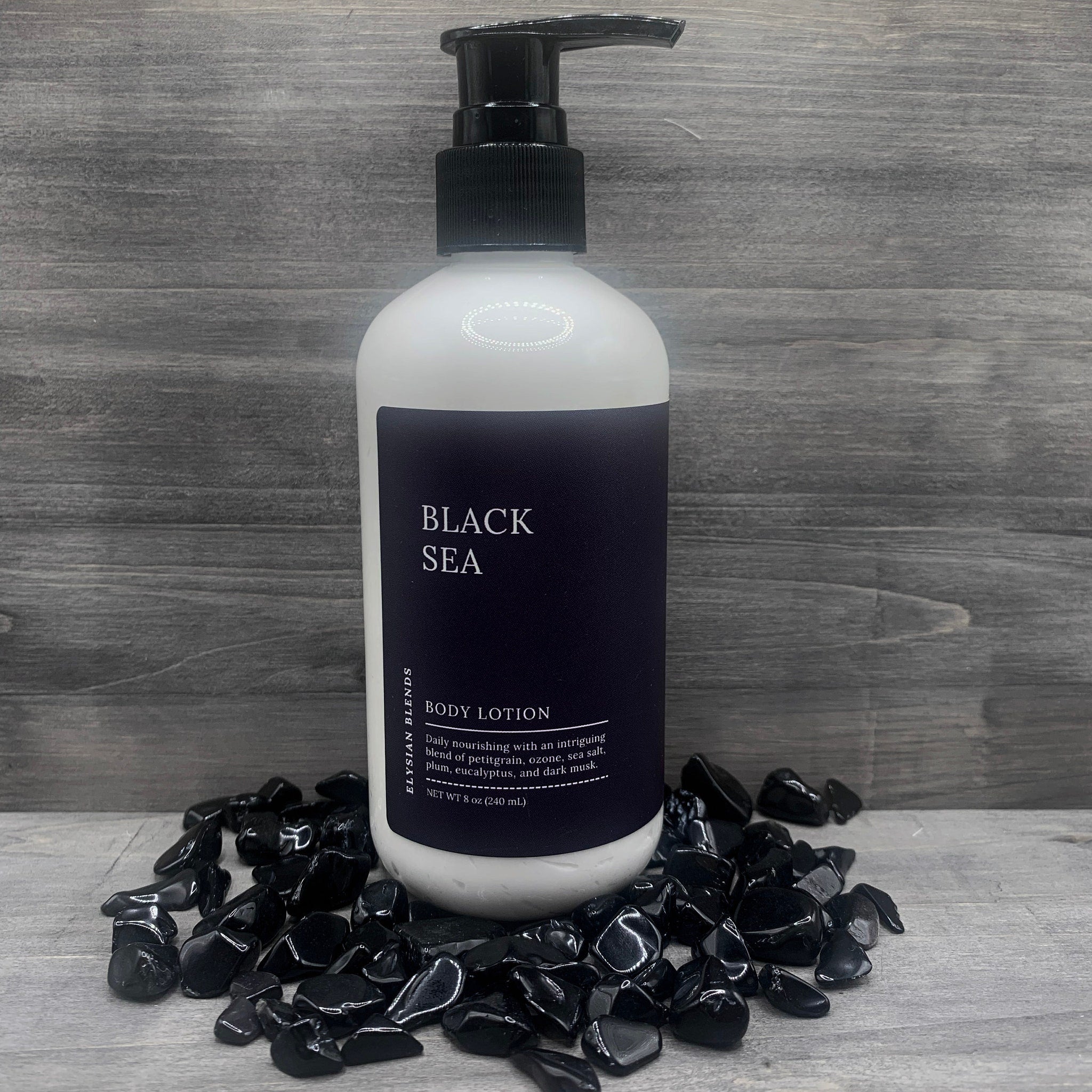 Body lotion bottle with black pump, white bottle, and black label, Elysian Blends brand name visible