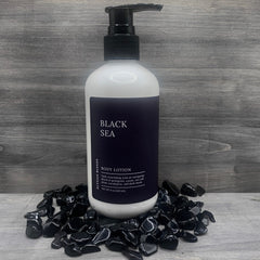 Body lotion bottle with black pump, white bottle, and black label, Elysian Blends brand name visible