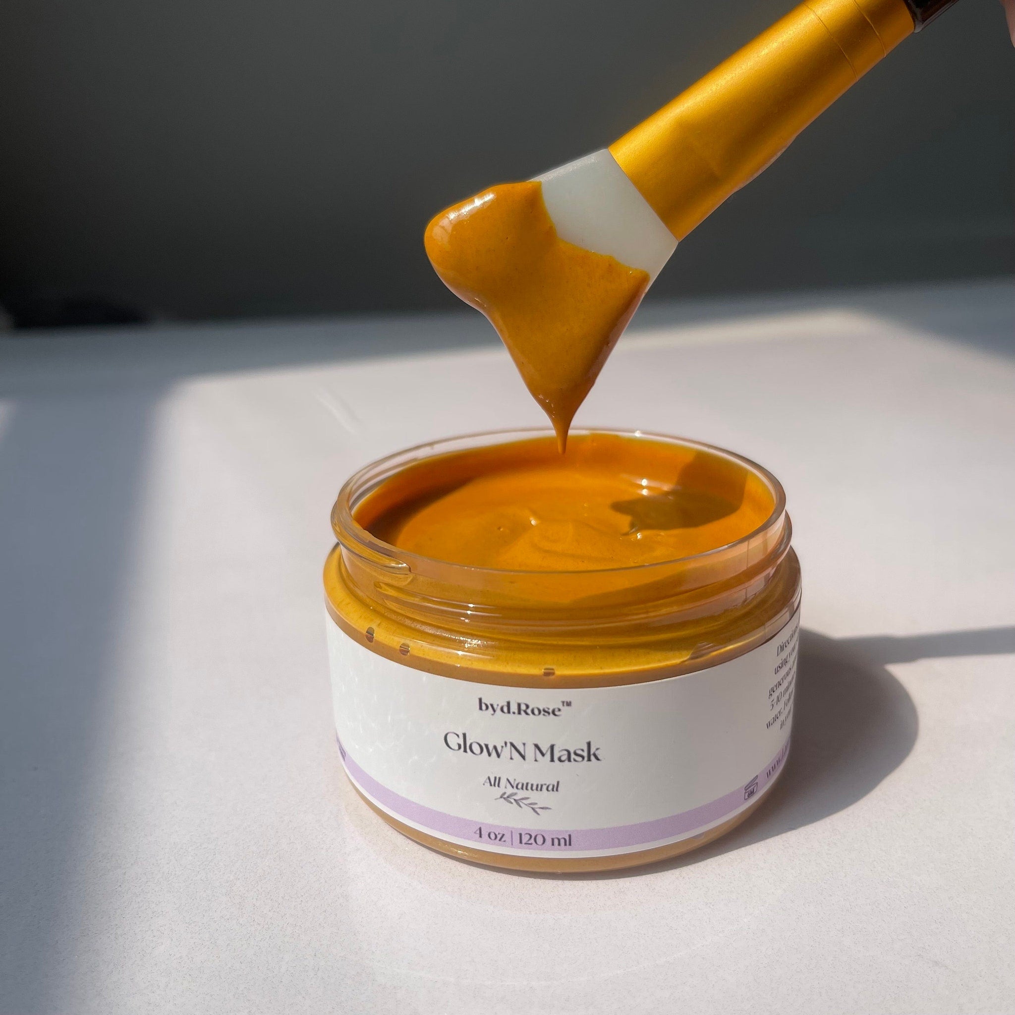 Turmeric exfoliating mask in jar with yellow brush, "Glow'N Mask" byLarose visible
