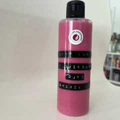 Close-up of vegan body wash and scrub duo with floral fragrance in minimalist frosted bottles, showcasing textured scrub