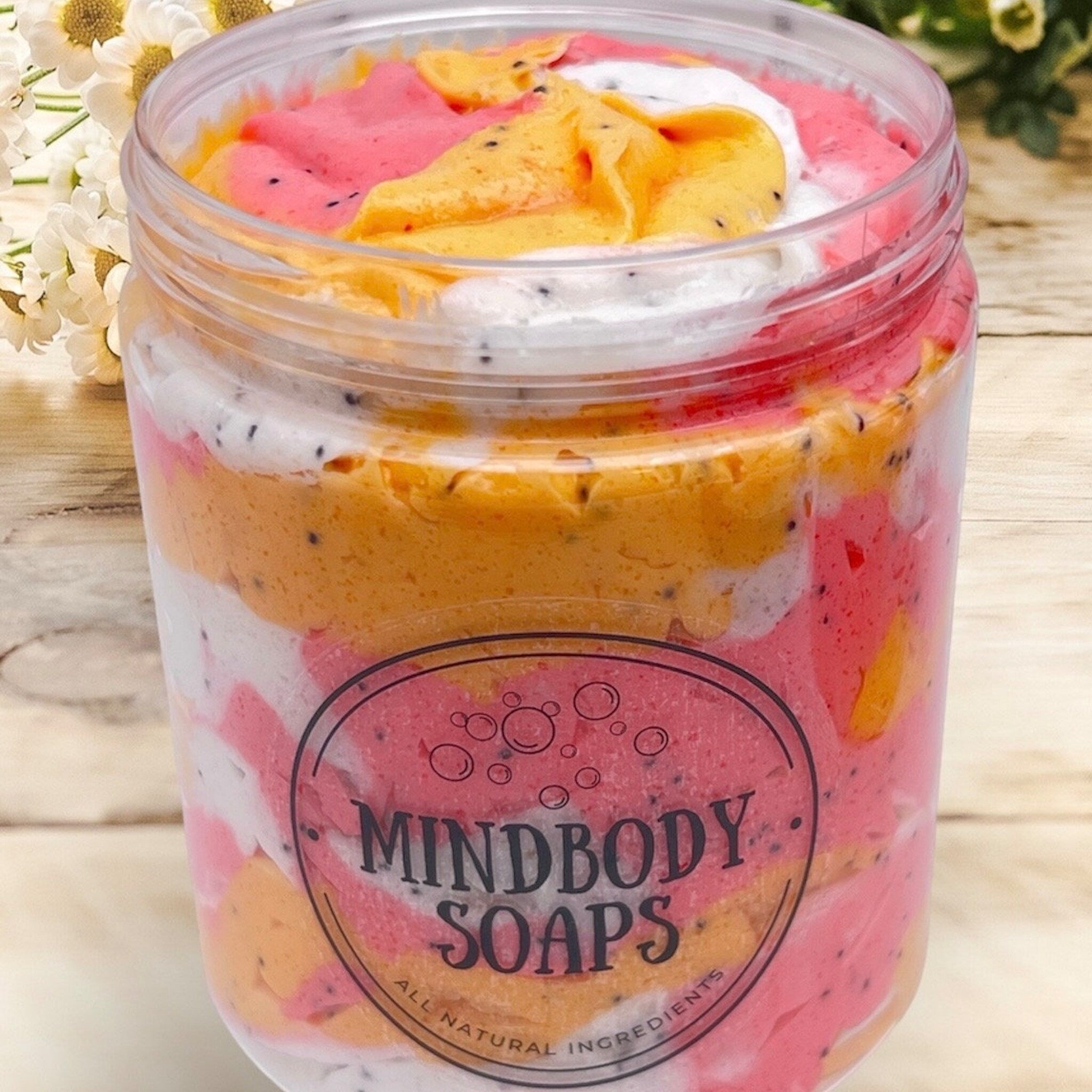 Soaps colorful layered with Mindbody Soaps brand in clear plastic jar, natural ingredients visible