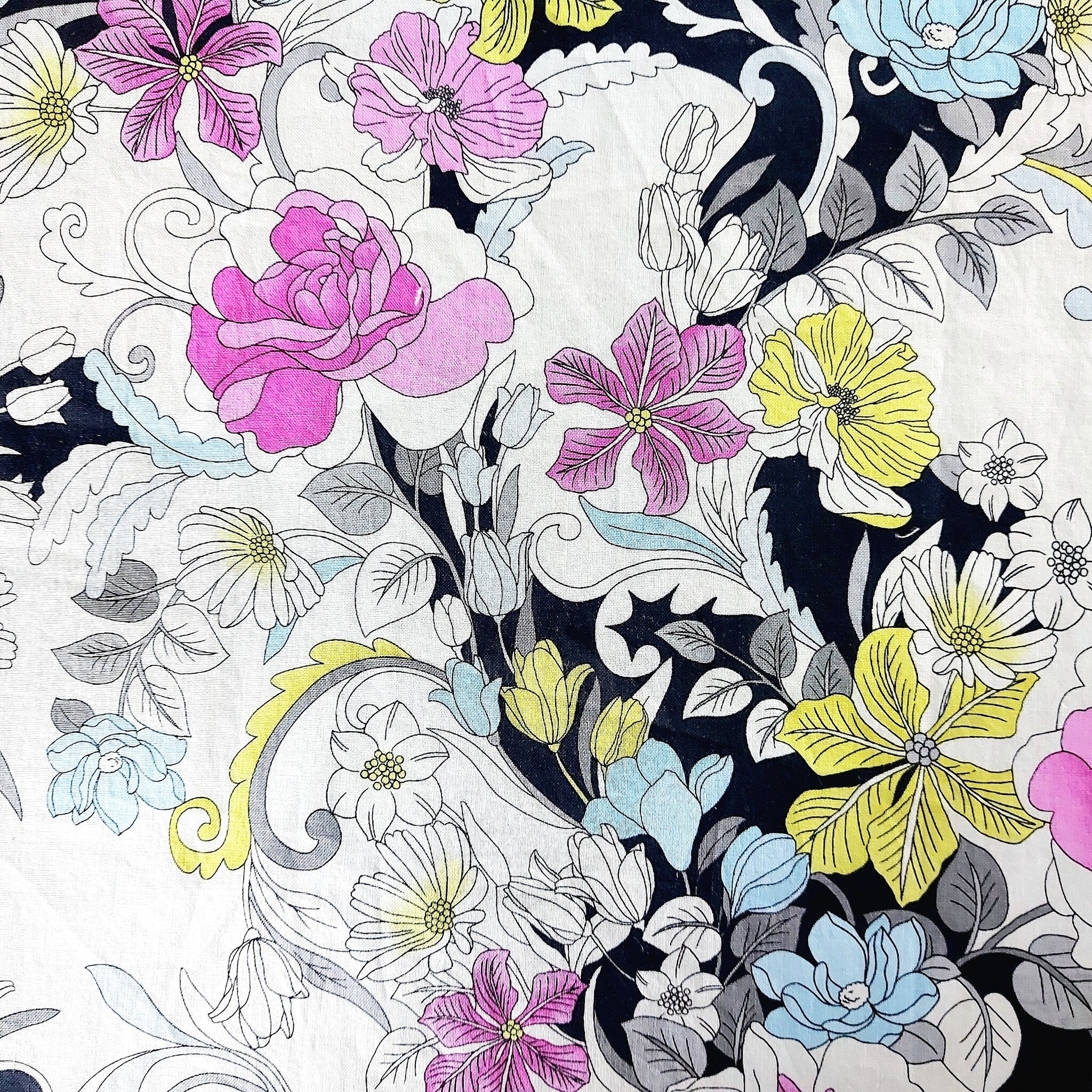 Floral fabric with pink, yellow, and blue flowers on white and black background, stylized design